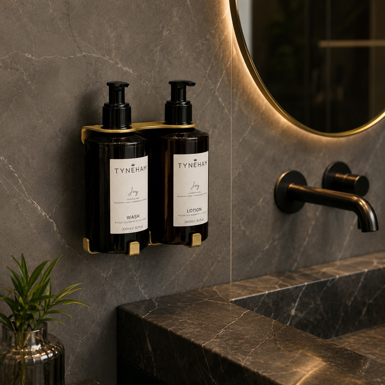 Two Tyneham amber bottles labeled 'Wash' and 'Lotion' on a wall-mounted gold holder in a bathroom setting.